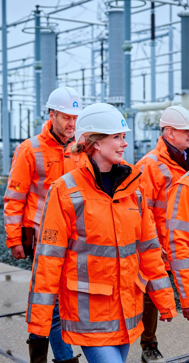 4 mannen, 1 vrouw VolkerWessels kleding lopen naar rechts